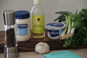 Ingredients for Green Goddess salad dressing on a wood tray