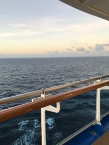 View of the ocean, overlooking a wood railing on the Regal Princess. Tips for first time cruisers.