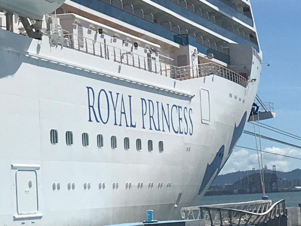 The bow of the Royal Princess takes by myself. The name of the ship id centered with only about 3 ship levels shown. The ship is tied down in port. 