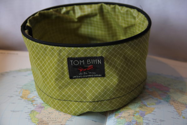 Large green Tom Bihn travel tray. Has a drawstring and is perfect for holding travel necessities.