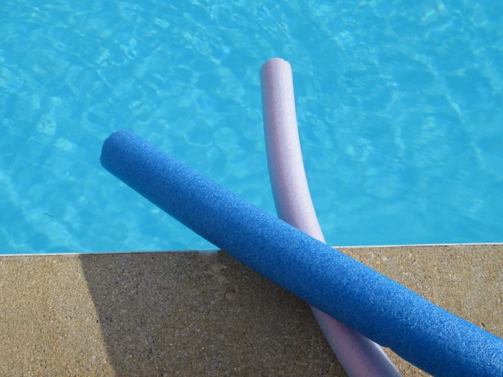 Two pool noodles, one blue and one light purple