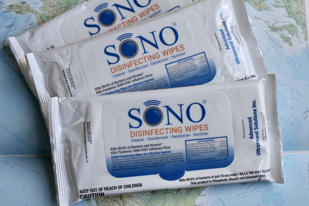 3 packages of medical disinfecting wipes, SONO brand, on a map of the Caribbean. How to Stay Healthy on a Cruise.