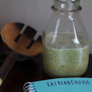 Polly's House Salad Dressing, made and in a glass jar, next to wood salad thongs, best salad dressing recipe