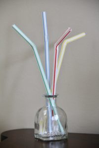 4 drinking straws in a clear glass vase, 3 are flexing and one is straight, showing 1 of 9 ways to ruin your cruise