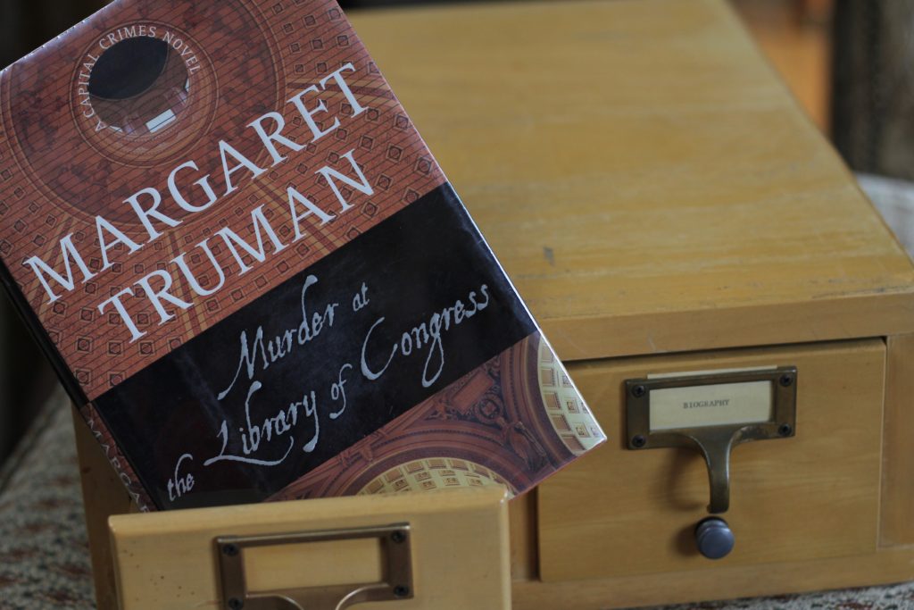 Hardcover of the book Murder at the Library of Congress, on an old two drawer oak card catalog